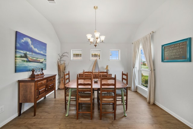 dining space with vaulted ceiling, wood finished floors, baseboards, and a chandelier