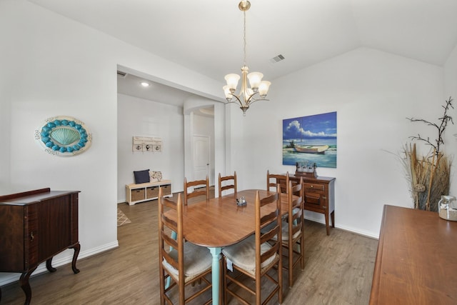 dining room with visible vents, lofted ceiling, wood finished floors, an inviting chandelier, and baseboards