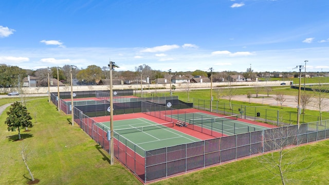 view of tennis court featuring a yard and fence