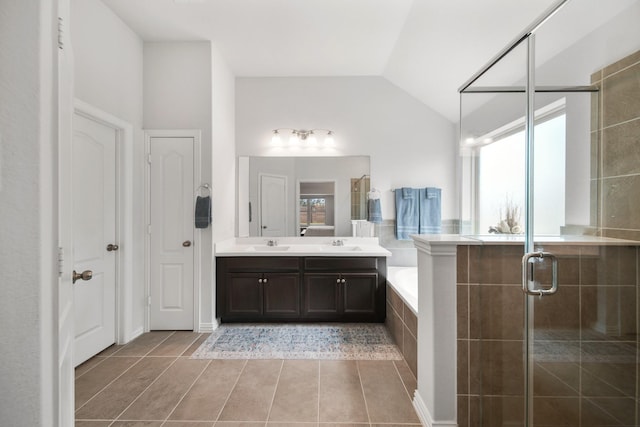 bathroom with a stall shower, a sink, double vanity, a bath, and vaulted ceiling