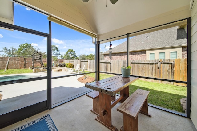 unfurnished sunroom featuring ceiling fan and vaulted ceiling