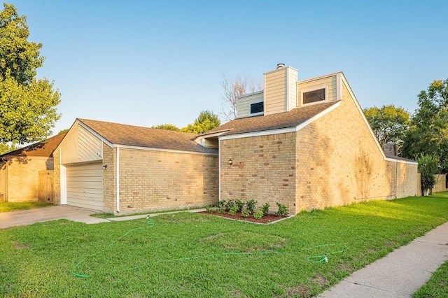 view of side of home with a chimney, concrete driveway, a garage, a lawn, and brick siding