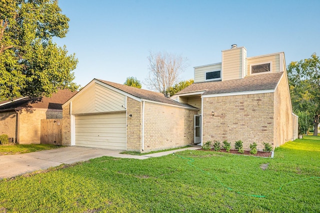 view of front of property featuring brick siding, concrete driveway, a front yard, a chimney, and a garage