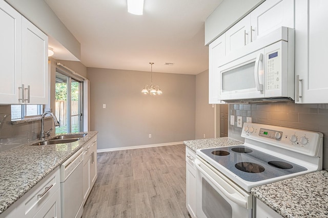 kitchen with baseboards, light wood-type flooring, white appliances, white cabinetry, and a sink