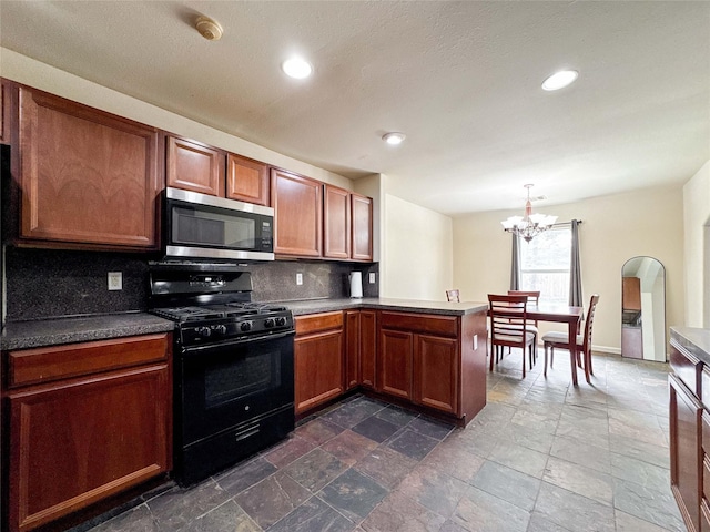 kitchen featuring a peninsula, black range with gas cooktop, stone finish flooring, stainless steel microwave, and backsplash