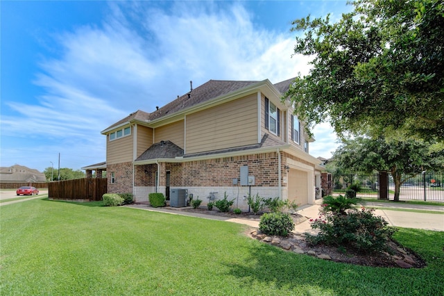 traditional-style house with central air condition unit, brick siding, concrete driveway, and fence