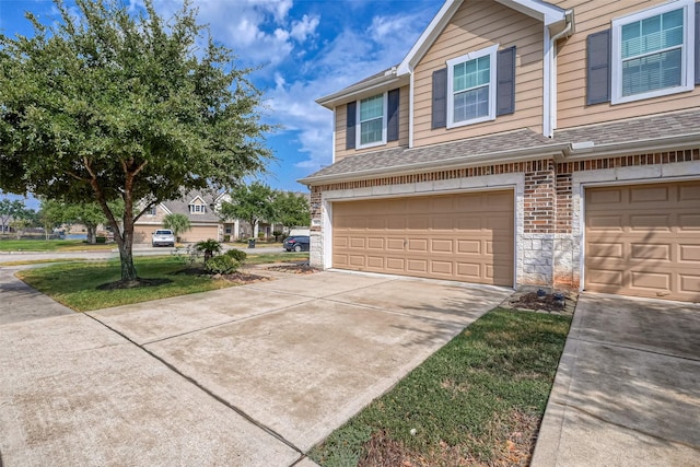 view of property exterior featuring a garage, brick siding, driveway, and a shingled roof