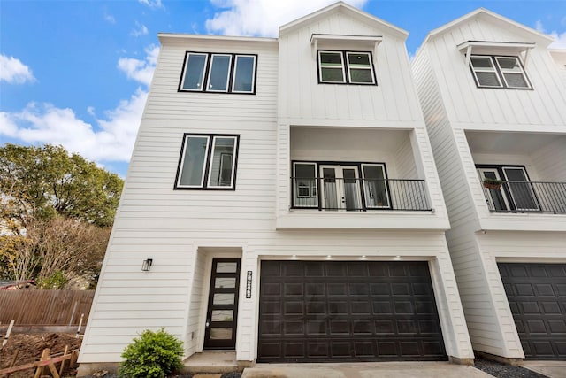 view of front of house featuring a balcony, board and batten siding, an attached garage, and fence