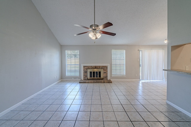 unfurnished living room featuring light tile patterned floors, baseboards, ceiling fan, a textured ceiling, and a brick fireplace