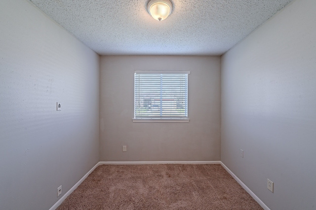 carpeted empty room featuring baseboards and a textured ceiling