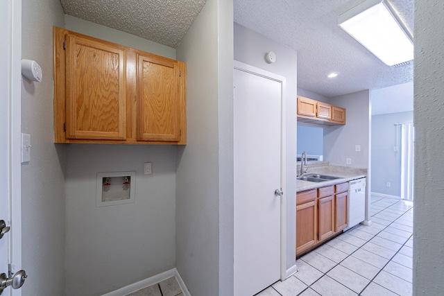 clothes washing area featuring washer hookup, a sink, a textured ceiling, cabinet space, and light tile patterned floors