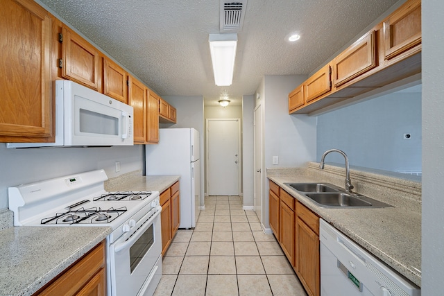 kitchen featuring visible vents, light countertops, light tile patterned flooring, white appliances, and a sink