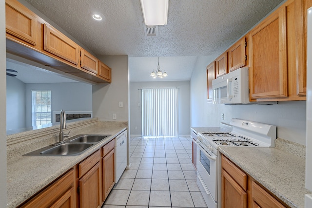 kitchen featuring white appliances, light tile patterned floors, a sink, light countertops, and a chandelier