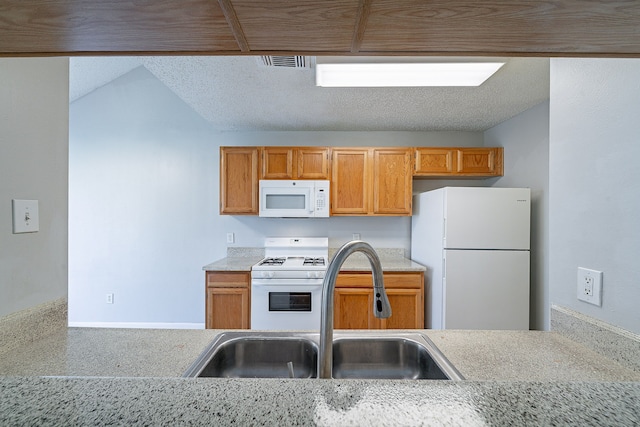 kitchen with a sink, visible vents, white appliances, and light countertops