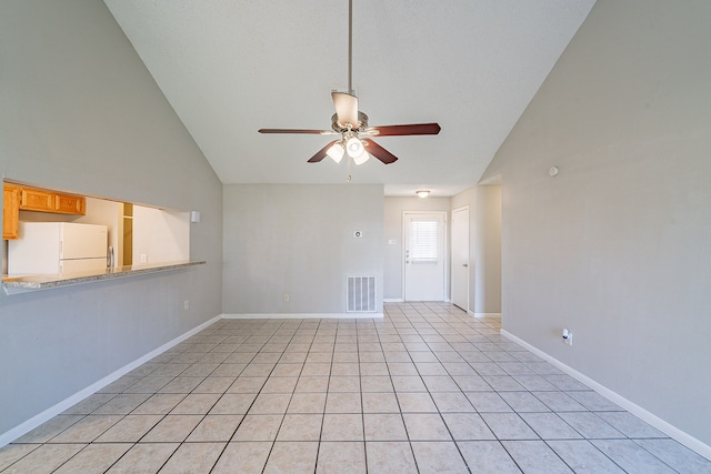 interior space with visible vents, high vaulted ceiling, light tile patterned floors, baseboards, and ceiling fan