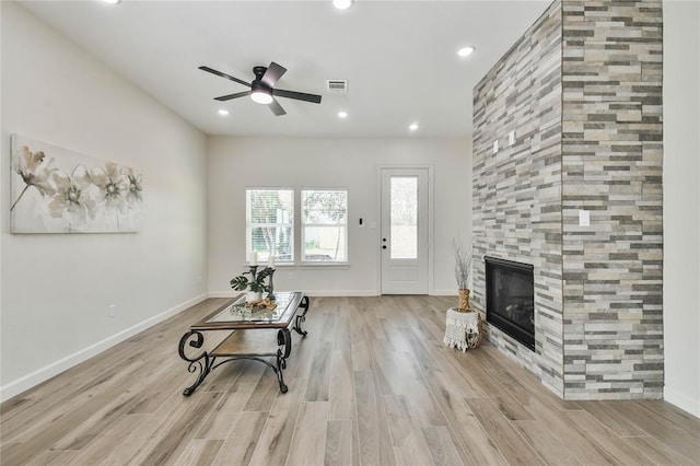 unfurnished living room featuring wood finished floors, visible vents, recessed lighting, ceiling fan, and a tiled fireplace