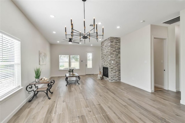 living area with baseboards, visible vents, light wood finished floors, recessed lighting, and a large fireplace