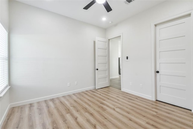 unfurnished bedroom with ceiling fan, baseboards, and light wood-style flooring