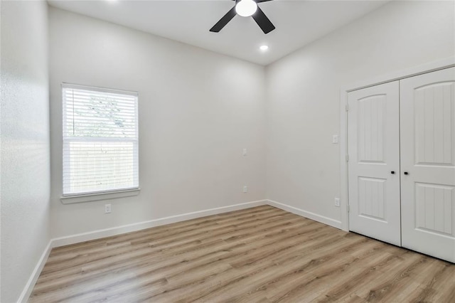 unfurnished bedroom with light wood-type flooring, baseboards, a closet, and a ceiling fan