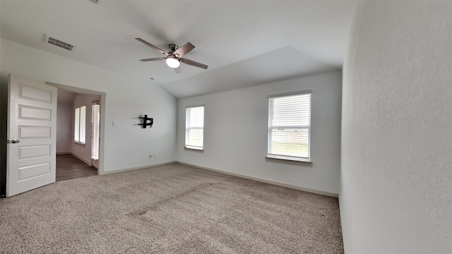 empty room with visible vents, baseboards, carpet, and vaulted ceiling