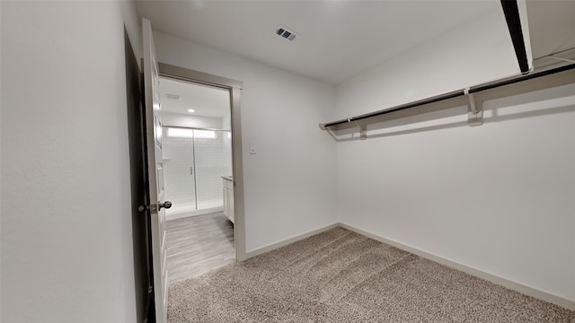 spacious closet with visible vents and light carpet