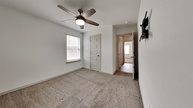 unfurnished bedroom with a ceiling fan, light colored carpet, and baseboards