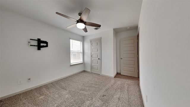 unfurnished bedroom featuring light carpet, visible vents, a ceiling fan, and baseboards