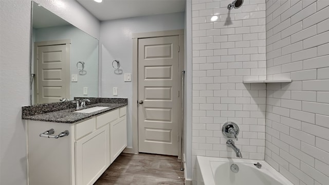 full bath with tub / shower combination, vanity, and wood finished floors