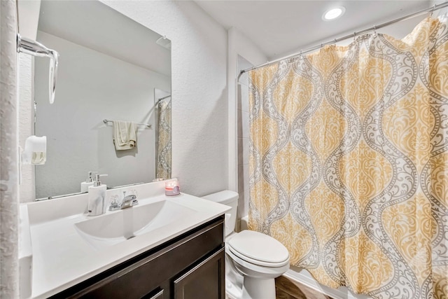 full bathroom featuring vanity, toilet, a shower with curtain, and a textured wall