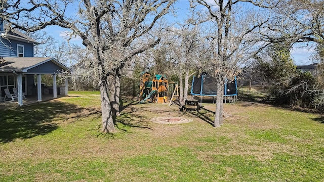 view of yard featuring a playground, a trampoline, and a sunroom