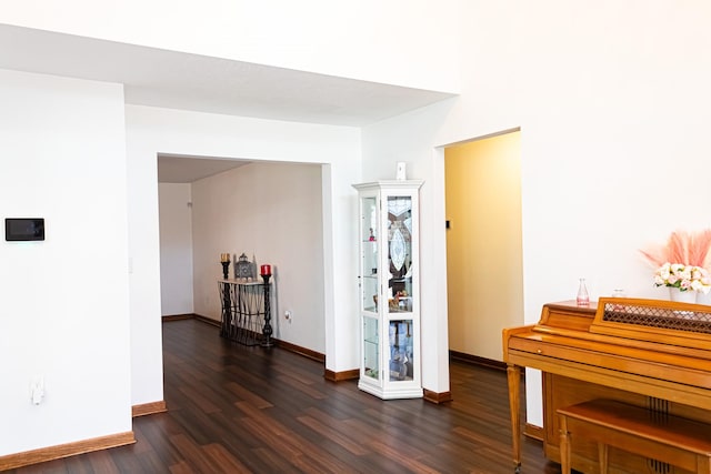 hallway with dark wood finished floors and baseboards