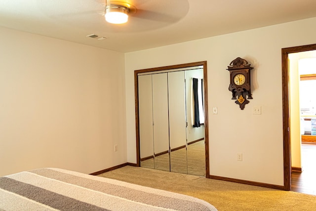 unfurnished bedroom with a ceiling fan, baseboards, visible vents, a closet, and light colored carpet