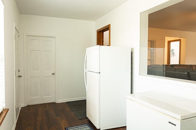 kitchen with visible vents, freestanding refrigerator, baseboards, and dark wood-style flooring