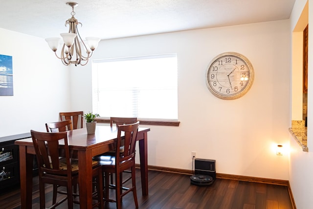 dining space featuring baseboards, a notable chandelier, and dark wood finished floors