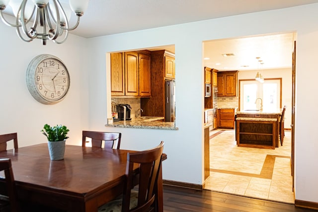 dining room with visible vents, baseboards, a chandelier, and light wood finished floors