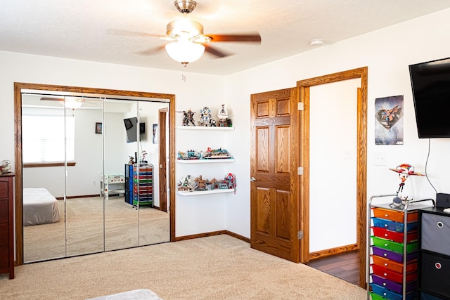 carpeted bedroom featuring a closet, a textured ceiling, a ceiling fan, and baseboards