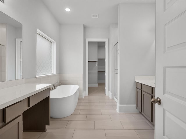 full bathroom featuring tile patterned floors, recessed lighting, a shower stall, a freestanding bath, and vanity