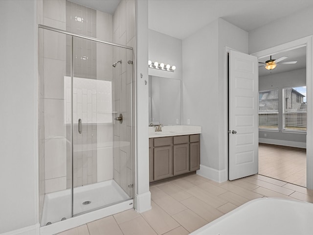 bathroom featuring baseboards, vanity, a stall shower, and a ceiling fan