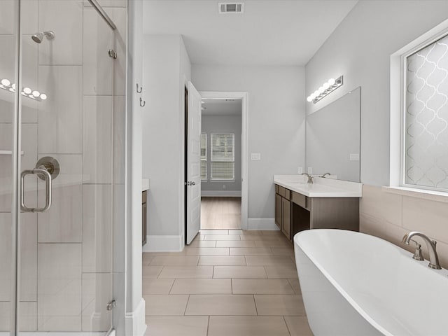 full bathroom featuring a soaking tub, visible vents, a stall shower, and vanity