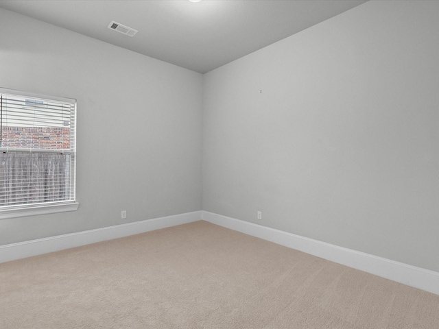 carpeted empty room featuring visible vents and baseboards