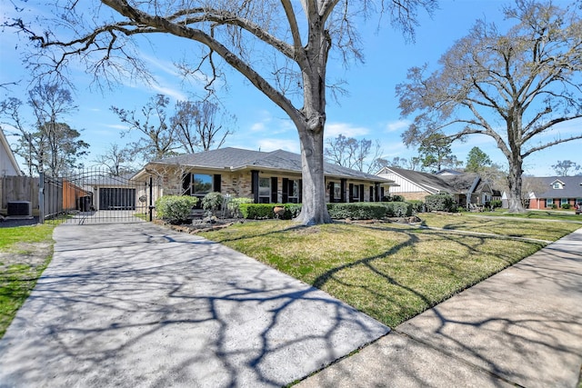 view of front of property with a gate, cooling unit, driveway, a front lawn, and brick siding