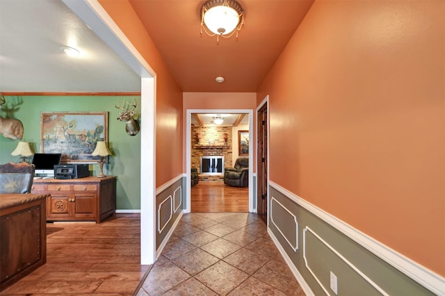 hallway featuring light wood finished floors and wainscoting