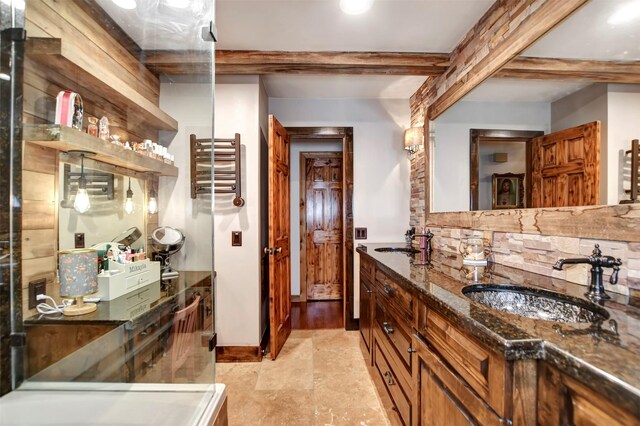 bathroom featuring decorative backsplash, double vanity, beam ceiling, and a sink