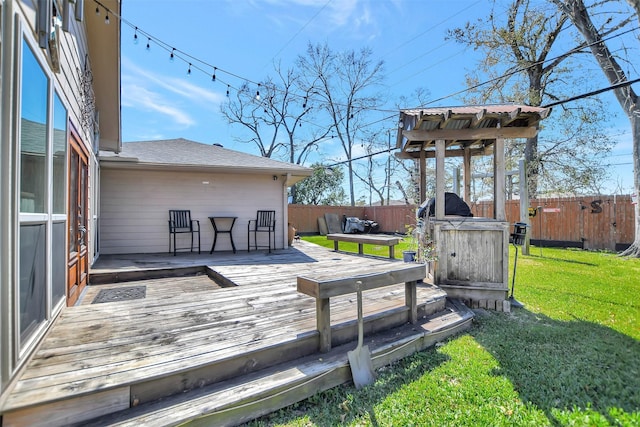 wooden deck featuring a lawn and fence