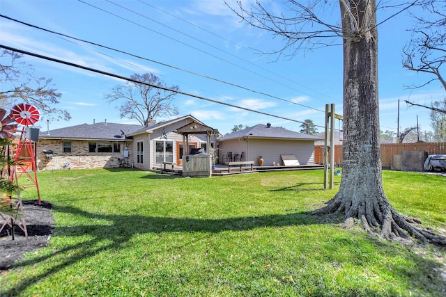 back of property featuring a yard, a deck, a chimney, and fence