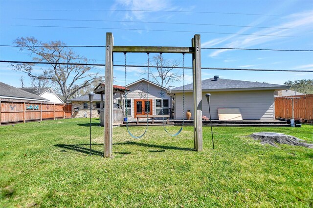 rear view of property featuring a lawn and a fenced backyard