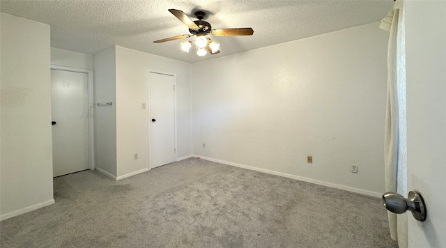 spare room featuring ceiling fan, baseboards, carpet floors, and a textured ceiling