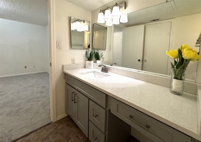 bathroom featuring visible vents, a textured ceiling, vanity, and baseboards