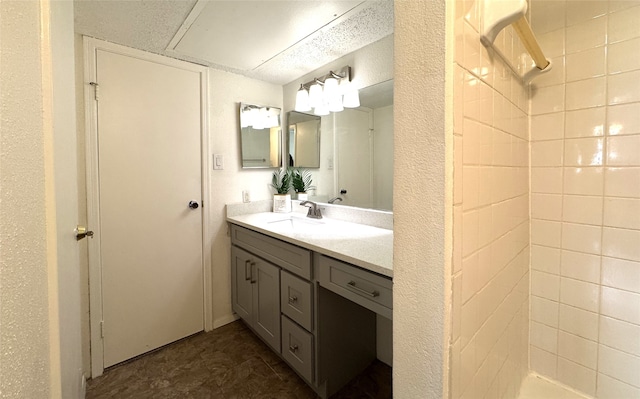 full bath with vanity and tiled shower