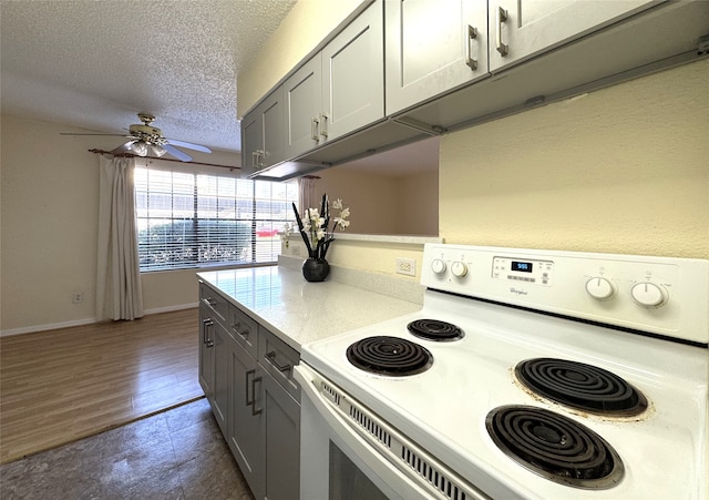 kitchen featuring white range with electric stovetop, gray cabinets, a textured ceiling, and light countertops